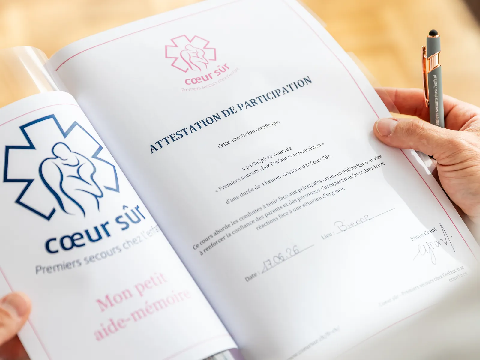 L'attestation de participation et le petit aide-mémoire remis à la fin du cours, feuilletés par un participant