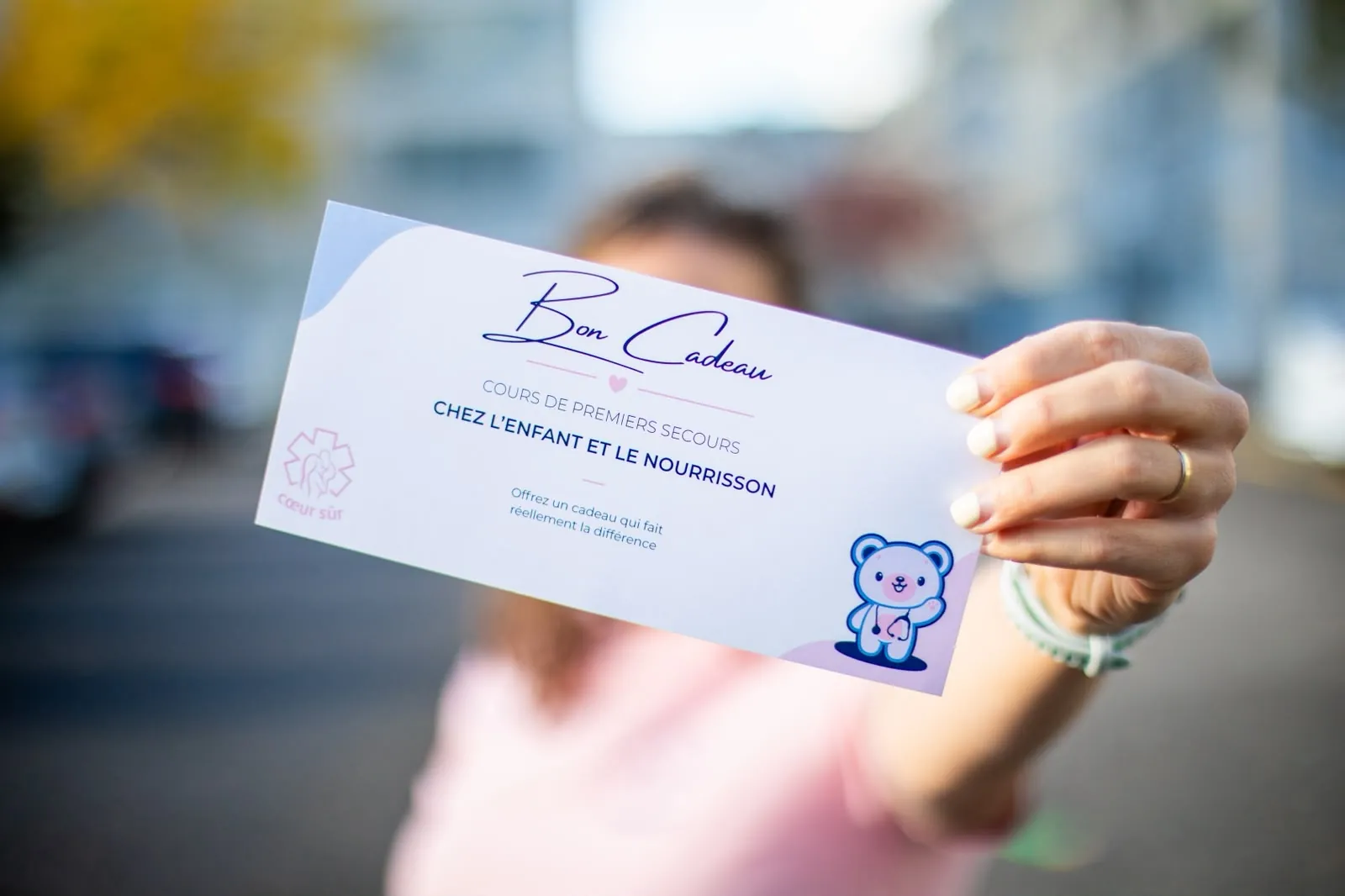 Emilie Grand tend le bon cadeau Cœur Sûr à bout de bras